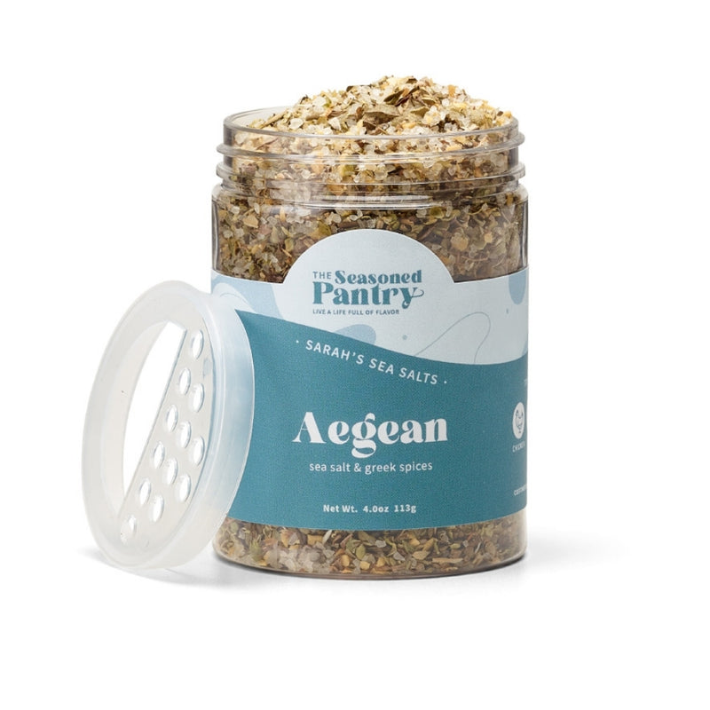 A clear jar containing medium grain Aegean sea salt blended with herbs and spices, with a blue label on the lid.
